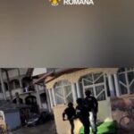Romanian Police officers in tactical gear entering a building on a rainy day, under a police banner logo at top.