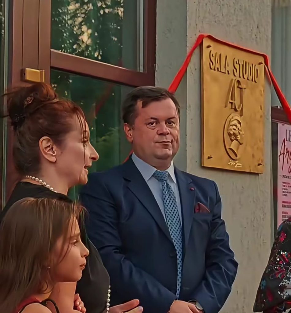 WhatsApp Image 2026-09-21 at 021016 6 - Jurnalul Olteniei – Știri din Craiova și Oltenia Group of well-dressed people at a storefront ceremony, a plaque reading 'Sala Studio' with red ribbon in the background.