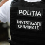 Back view of a Romanian police officer wearing a bulletproof vest labeled POLIȚIA and INVESTIGAȚII CRIMINALE (Criminal Investigations).