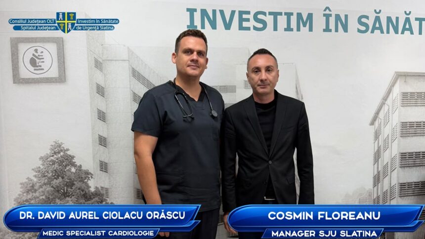 Two men pose for a photo in front of a medical-themed backdrop; one in scrubs with a stethoscope, the other in a black suit, with blue name banners at the bottom.