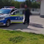 Romanian police car with crest; two officers talk to blurred individuals on a sunny street.