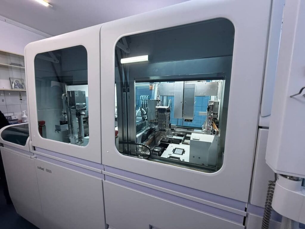 1000262376 - Jurnalul Olteniei – Știri din Craiova și Oltenia Automated laboratory analyzer with a closed observation chamber and robotic components inside a clinical lab setup (Cobas 6800).