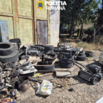 Outdoors, a junkyard scene with tires and car parts scattered on a dirt ground in front of a weathered building, with a Romanian Police logo overlay.