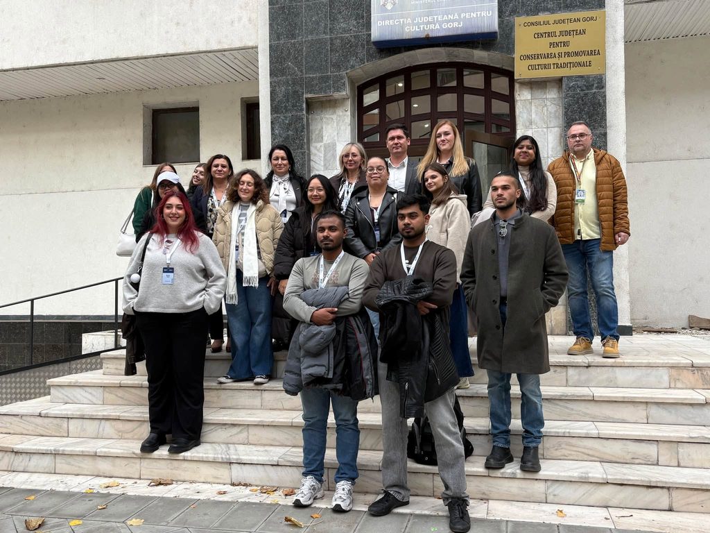 868542031_1549151563922982_6263556850173750470_n - Jurnalul Olteniei – Știri din Craiova și Oltenia Group of diverse young adults posing for a photo on marble steps outside a building with signs overhead
