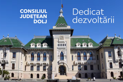 Front view of a grand civic building with a green roof and steps, under a blue sky; white Romanian text on the facade reads “CONSILIUL JUDETEAN DOLJ” and “Dedicat dezvoltării.”