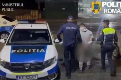 Nighttime street scene of Romanian police detaining a handcuffed suspect, with officers and a marked POLITIA car nearby.
