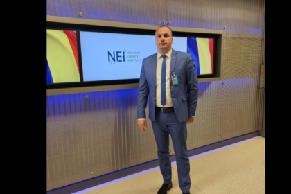 Man in a blue suit and tie standing in front of a Nuclear Energy Institute display.
