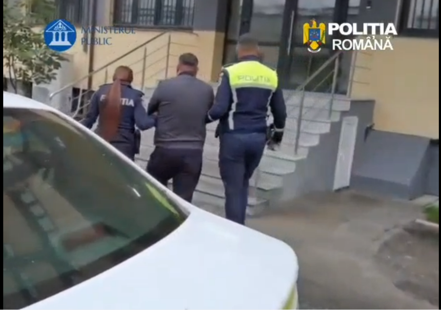 Two Romanian police officers escort a man up exterior stairs toward a building, with Ministerul Public and Politia Romana logos visible.