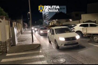 Nighttime street scene with several cars driving in a line, police emblem 'Poliția Română' overlaid at the top left.