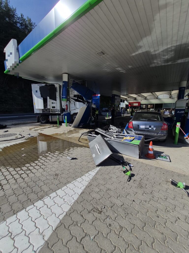 WhatsApp Image 2026-10-06 at 135322 - Jurnalul Olteniei – Știri din Craiova și Oltenia Gas station with a collapsed canopy and scattered debris after an accident; a damaged truck trailer under the canopy and a gray car in the foreground.