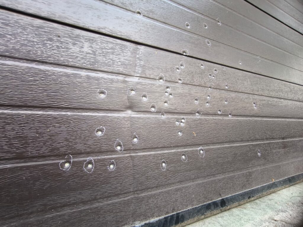 WhatsApp Image 2026-10-22 at 152109 - Jurnalul Olteniei – Știri din Craiova și Oltenia Dark brown wooden wall with scattered water droplets beaded on the surface.