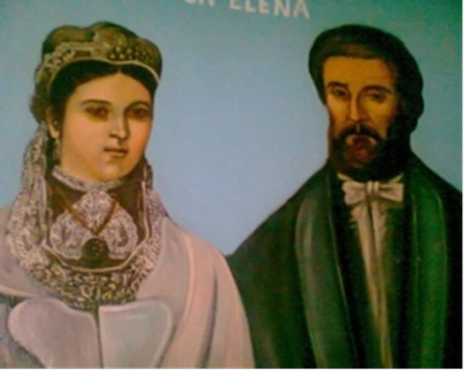 Portrait of a woman in an ornate headdress and white gown beside a bearded man in a dark suit against a blue background.