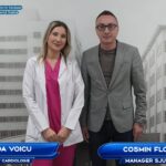 Dr. Anda Voicu, cardiology specialist, and Cosmin Floreanu, manager, pose in front of a hospital backdrop.