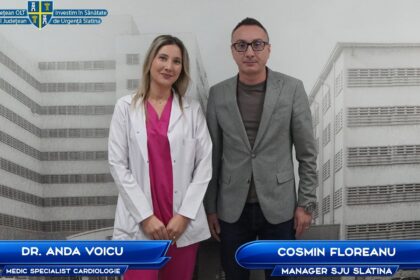 Dr. Anda Voicu, cardiology specialist, and Cosmin Floreanu, manager, pose in front of a hospital backdrop.