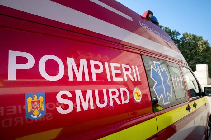 Red emergency ambulance with 'POMPIERII SMURD' text and Star of Life emblem on the side, parked outdoors.