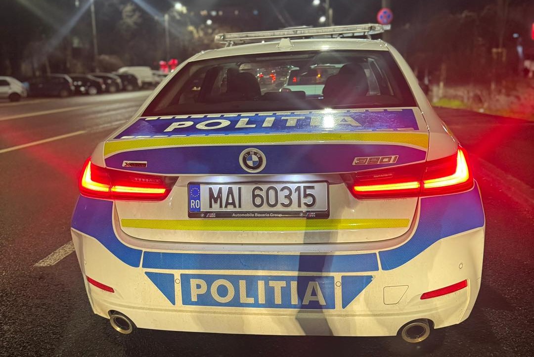 Rear view of a Romanian police car at night with red taillights, blue-yellow livery, and 'POLITIA' markings; license MAI 60315.